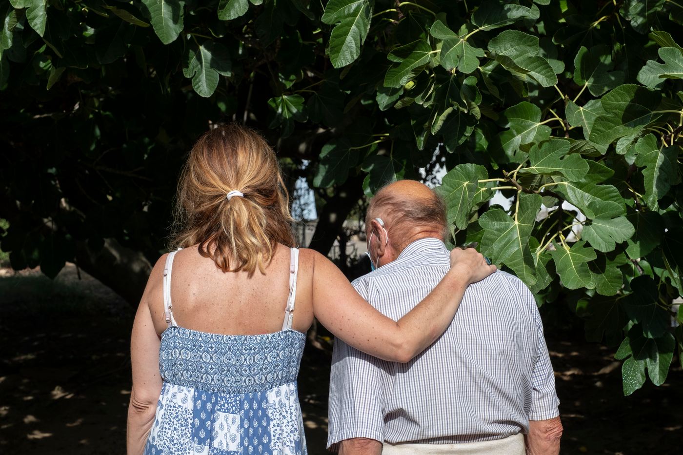 Caregiver walking outdoors with an older adult