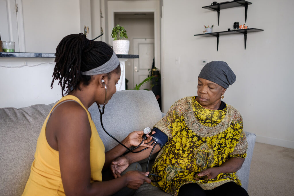 Home health aide monitoring an older adult's wellness
